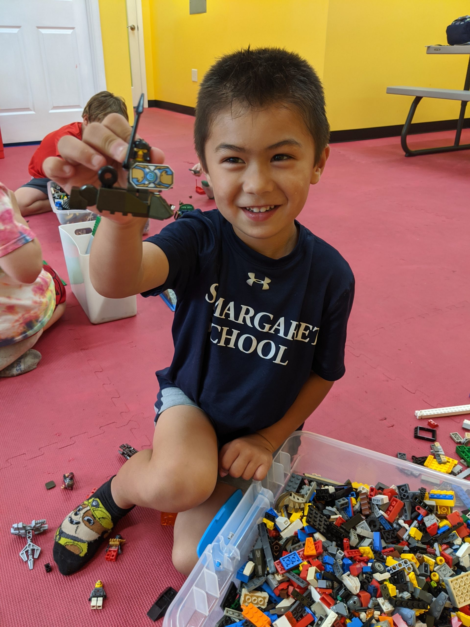 Boy holds Lego creation during Fun Fridays at The Playroom near Bel Air, MD